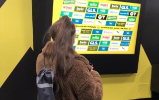 Senajla Ikic steht vor einem Bildschirm im Signal Iduna Park
